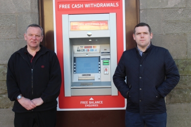 Paul and Douglas stand next to the ATM 